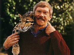 Charles Fracé holding a clouded leopard over his shoulder